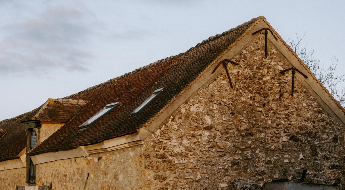 A stone farmhouse in the countryside at sunset